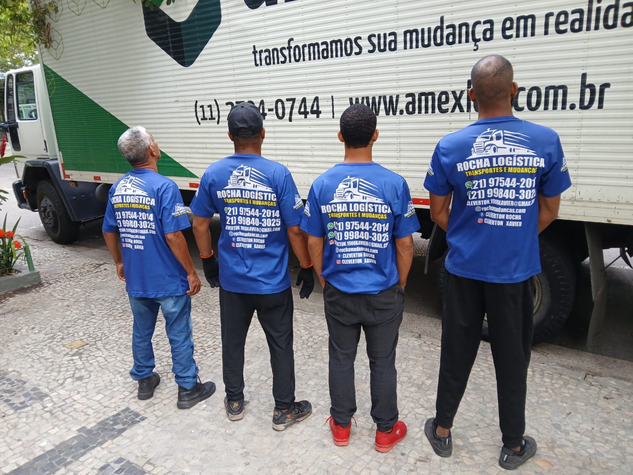 Equipe uniformizada junto ao caminhão de mudança