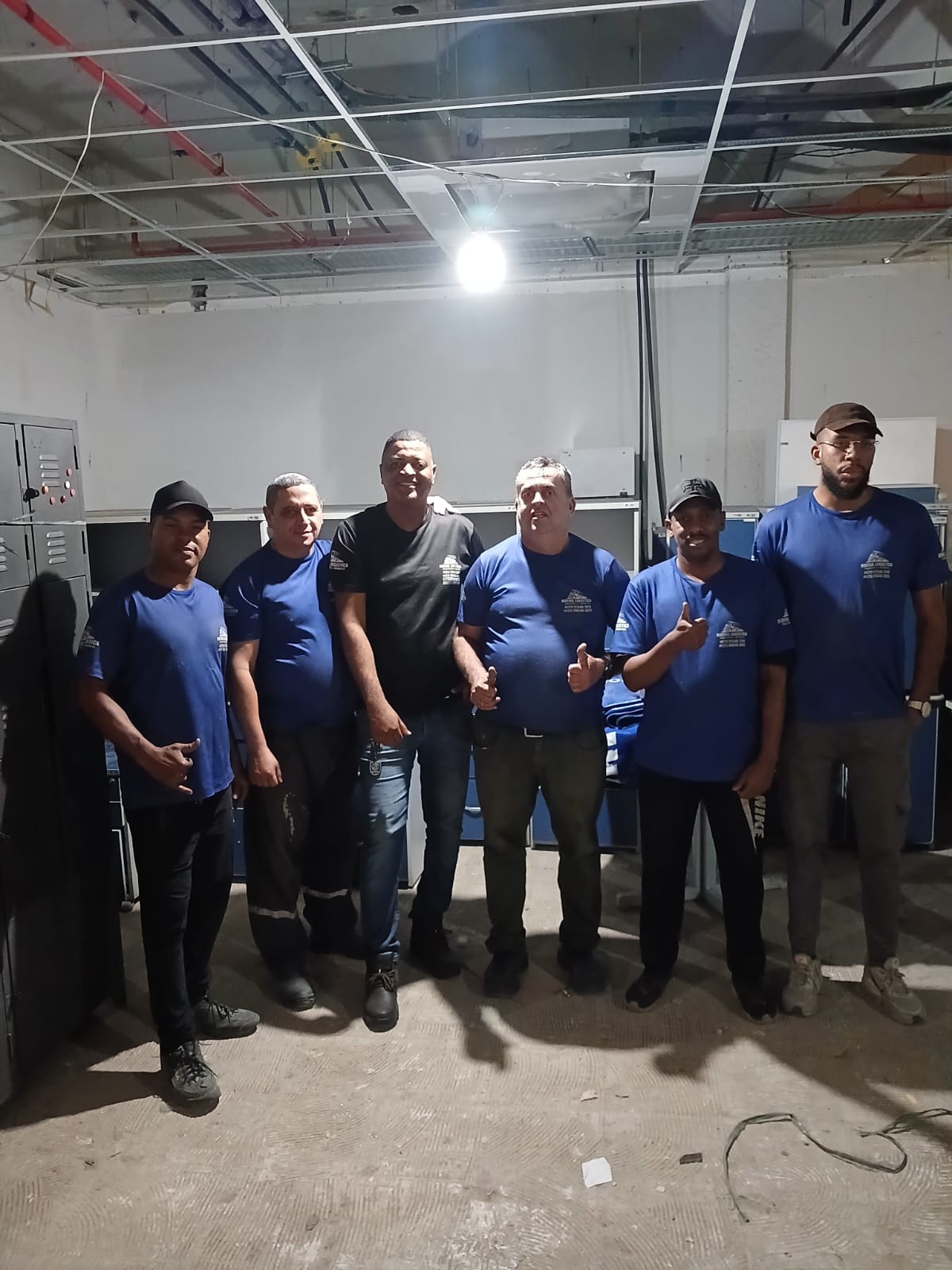 Equipe uniformizada de camisetas azuis Rocha Logística reunida no local do serviço