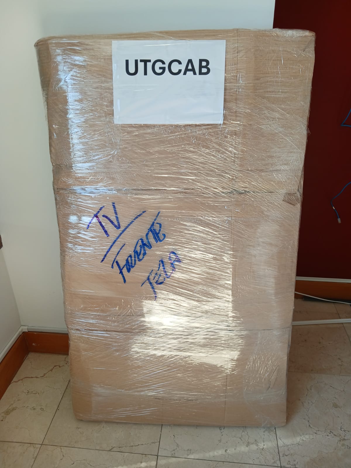 Móvel grande embalado em papelão e plástico-filme, identificado para transporte